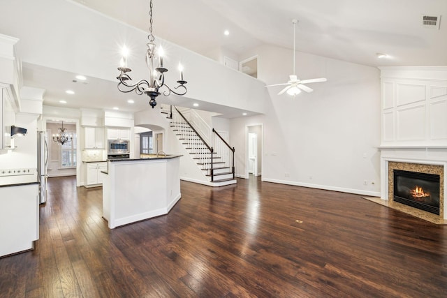 kitchen with stainless steel appliances, visible vents, white cabinetry, open floor plan, and dark countertops