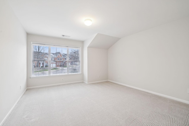 additional living space with light carpet, visible vents, and baseboards