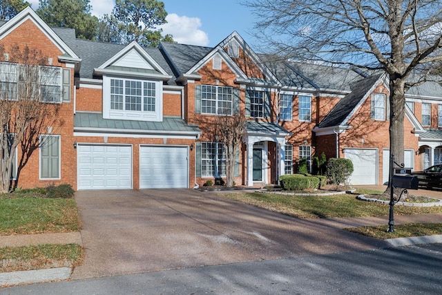 view of front of property with concrete driveway, metal roof, an attached garage, a standing seam roof, and brick siding