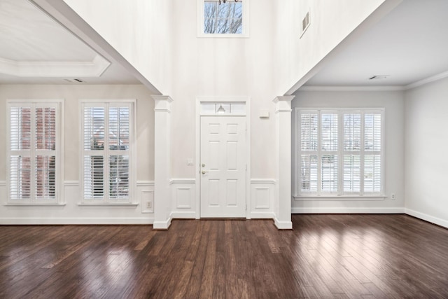 entryway with ornamental molding, dark wood finished floors, visible vents, and decorative columns