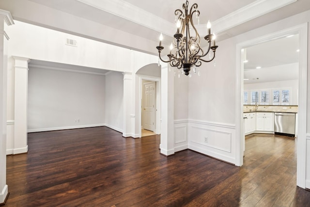 unfurnished dining area with arched walkways, a sink, visible vents, dark wood finished floors, and ornate columns