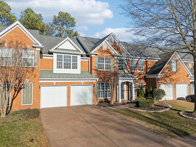 view of front facade featuring concrete driveway, metal roof, an attached garage, a standing seam roof, and brick siding