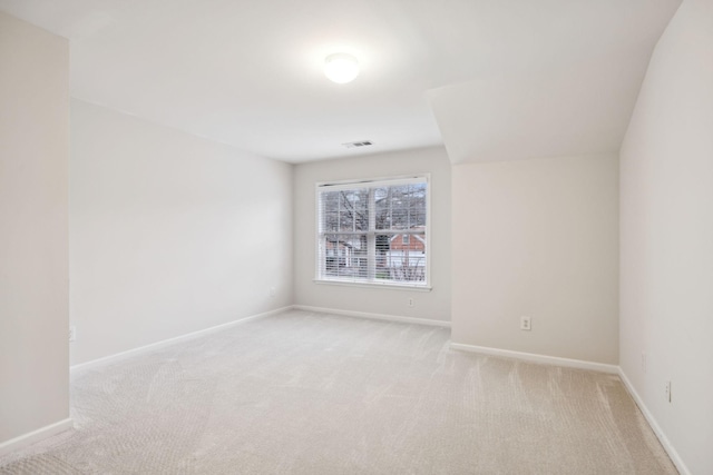 spare room with light carpet, visible vents, and baseboards