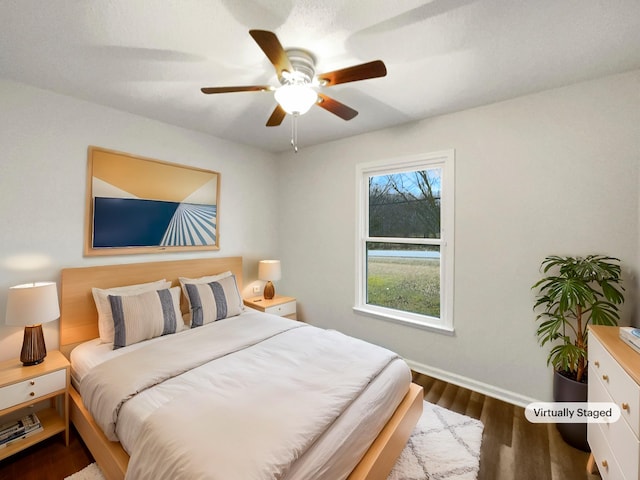 bedroom featuring dark wood-type flooring, baseboards, and a ceiling fan