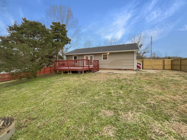 rear view of property featuring a fenced backyard, a lawn, and a deck