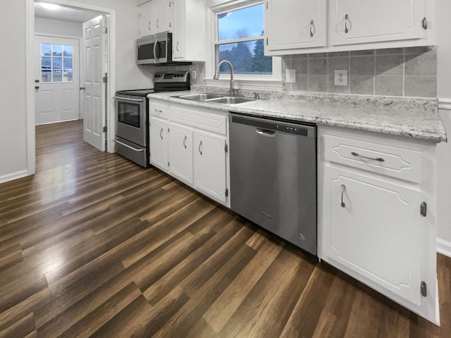 kitchen featuring appliances with stainless steel finishes, light countertops, white cabinets, and a sink