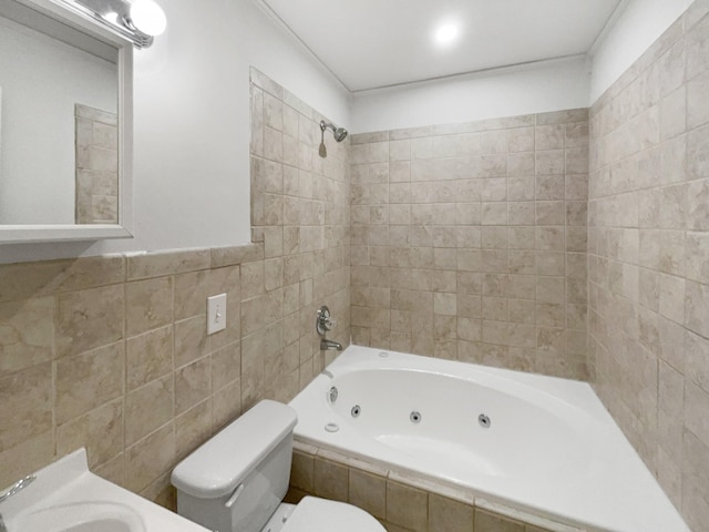 full bathroom featuring a combined bath / shower with jetted tub, a sink, toilet, and tile walls