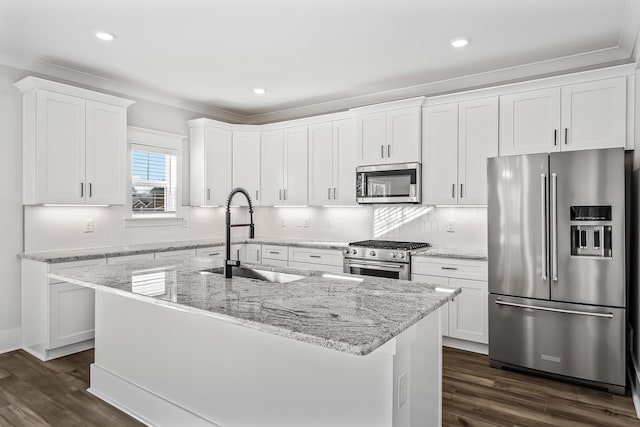 kitchen with a center island with sink, white cabinetry, high end appliances, and a sink