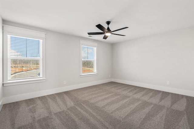 carpeted spare room with baseboards and a ceiling fan