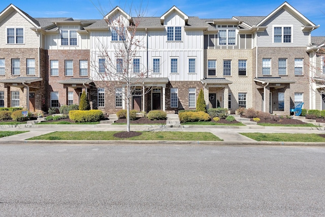 townhome / multi-family property featuring brick siding and board and batten siding