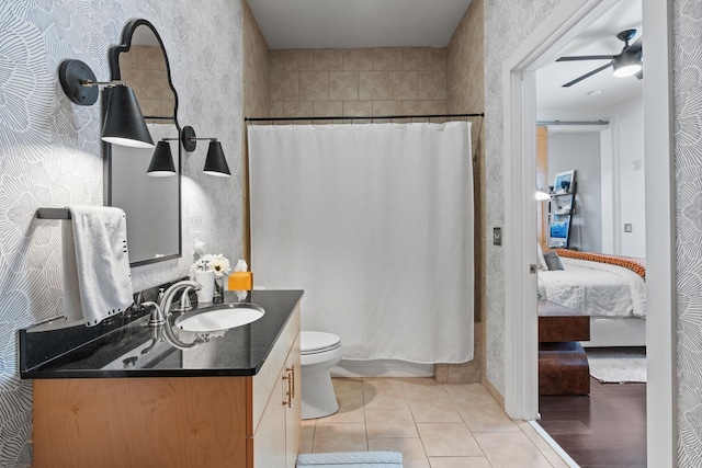 ensuite bathroom featuring a ceiling fan, connected bathroom, toilet, tile patterned floors, and vanity