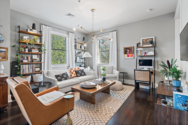 living area featuring visible vents, a chandelier, and wood finished floors