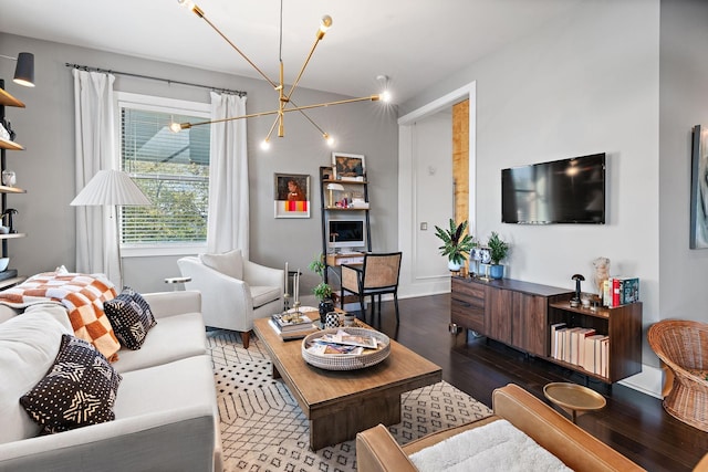 living area with a chandelier, dark wood-style flooring, and baseboards