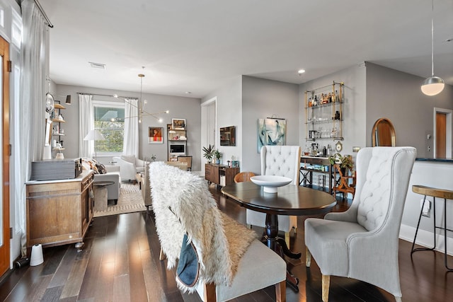 dining space with a notable chandelier, visible vents, and dark wood-style flooring