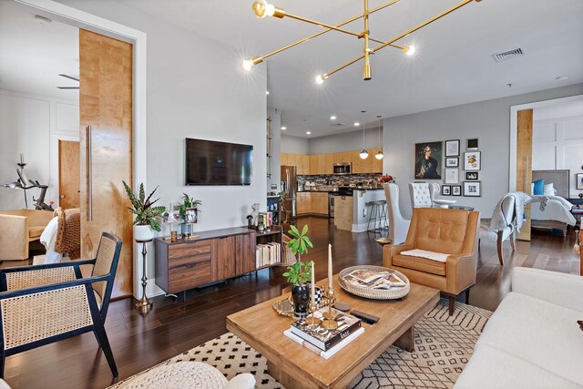 living room featuring dark wood-style floors, recessed lighting, visible vents, and an inviting chandelier