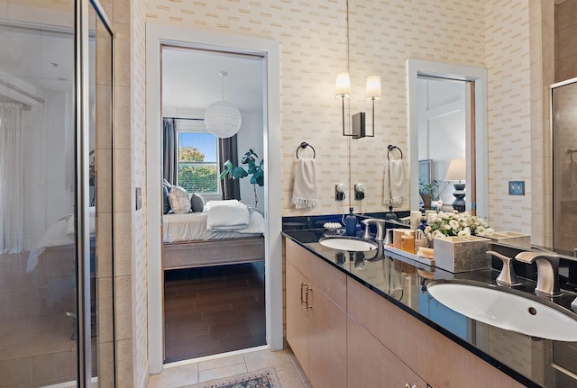 ensuite bathroom featuring double vanity, a sink, ensuite bath, and tile patterned floors