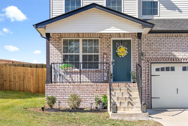 view of front facade with a garage, brick siding, and fence