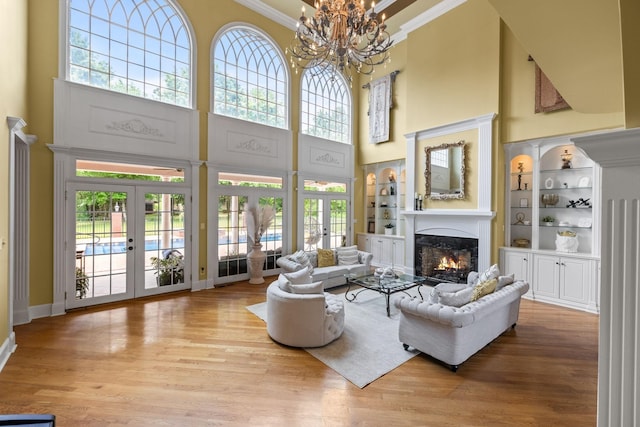 1465 New Columbia Hwy, Lewisburg, TN 37091 - living area featuring ornamental molding, a warm lit fireplace, wood finished floors, french doors, and an inviting chandelier