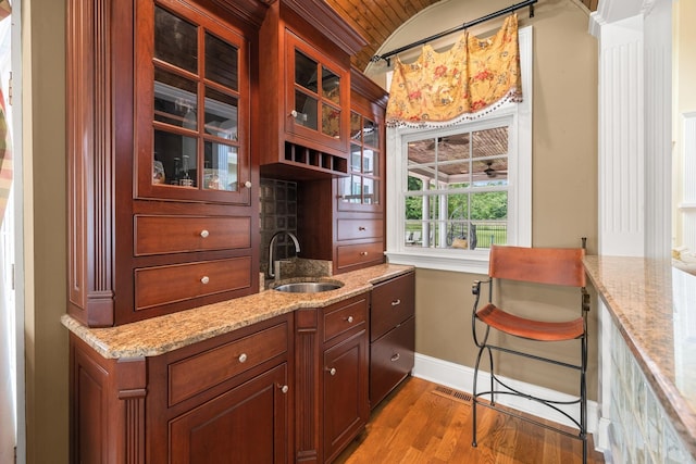 1465 New Columbia Hwy, Lewisburg, TN 37091 - kitchen featuring a sink, wood finished floors, glass insert cabinets, baseboards, and light stone countertops