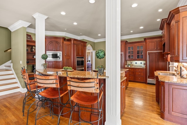 1465 New Columbia Hwy, Lewisburg, TN 37091 - kitchen featuring a kitchen bar, light wood-type flooring, a sink, stainless steel microwave, and ornate columns