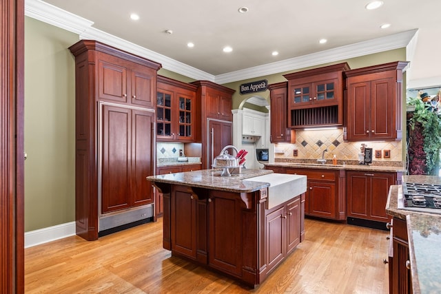 1465 New Columbia Hwy, Lewisburg, TN 37091 - kitchen with a breakfast bar area, light wood-style flooring, an island with sink, crown molding, and tasteful backsplash