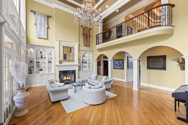 1465 New Columbia Hwy, Lewisburg, TN 37091 - living area with wood finished floors, an inviting chandelier, arched walkways, a warm lit fireplace, and crown molding