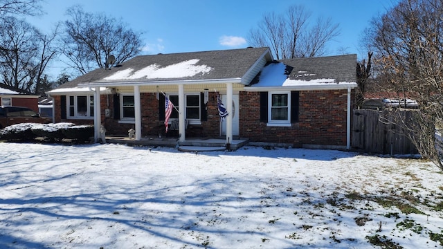 view of front of home featuring brick siding and fence