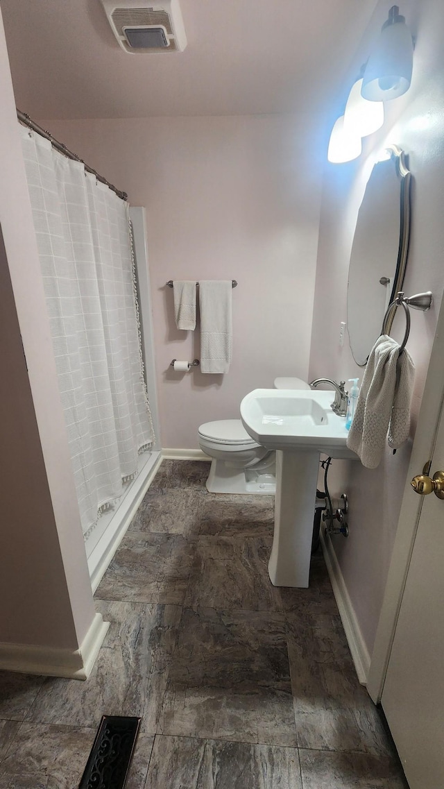 bathroom featuring toilet, a shower stall, visible vents, and baseboards