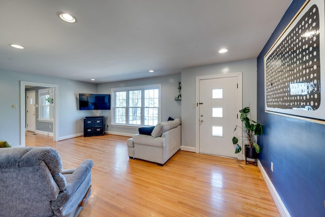 living area with baseboards, light wood-style flooring, and recessed lighting