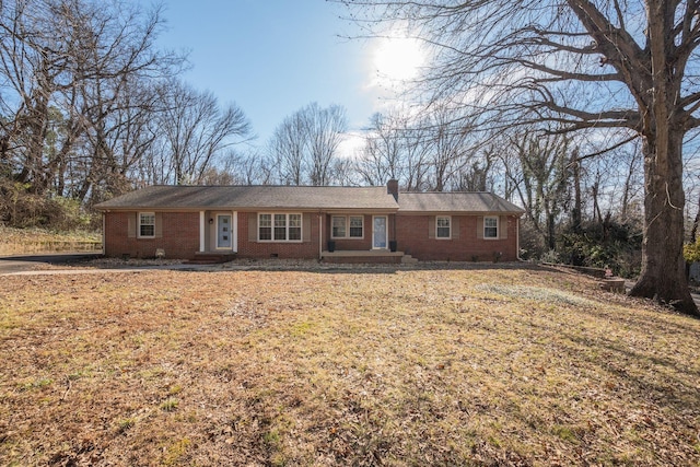 single story home featuring a front yard, crawl space, brick siding, and a chimney