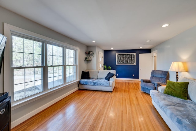 living room featuring recessed lighting, baseboards, and light wood finished floors