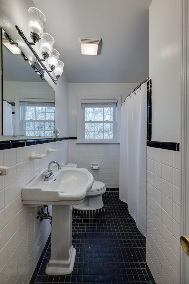 bathroom featuring visible vents, tile walls, toilet, and tile patterned floors