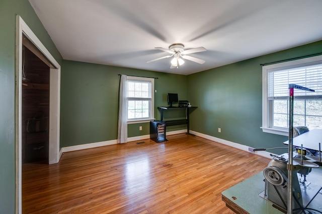 unfurnished office featuring ceiling fan, light wood-style flooring, and baseboards