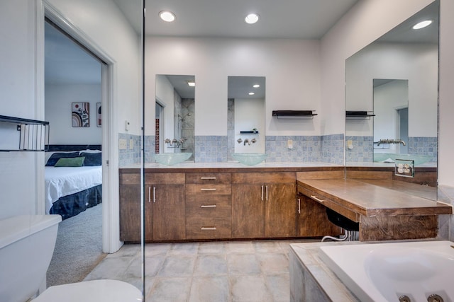 ensuite bathroom with ensuite bathroom, double vanity, a sink, and toilet