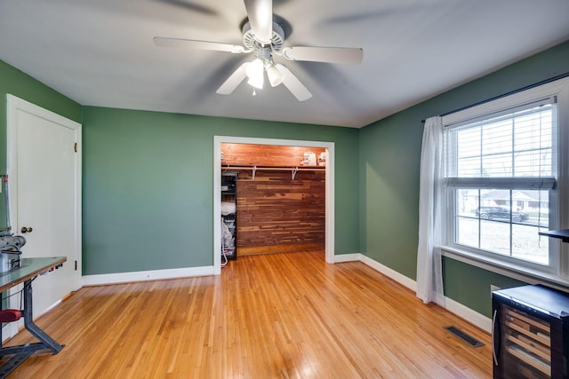 unfurnished room featuring light wood-style flooring, visible vents, ceiling fan, and baseboards