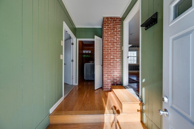 hallway with wood finished floors and crown molding