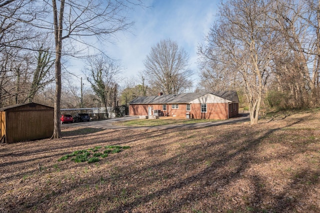 view of front of house with an outbuilding, driveway, and a chimney