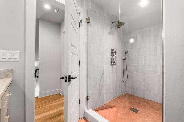 bathroom with recessed lighting, wood finished floors, vanity, and walk in shower