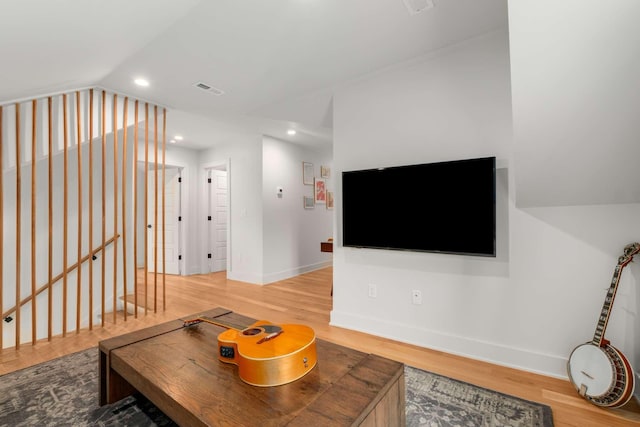 living room with vaulted ceiling, wood finished floors, visible vents, and recessed lighting