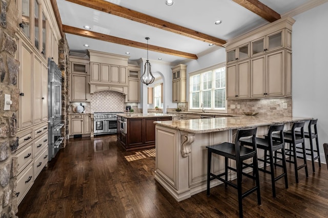 6054 Pelican Way, College Grove, TN 37046 - kitchen with cream cabinets, premium appliances, beam ceiling, dark wood-style flooring, and a peninsula