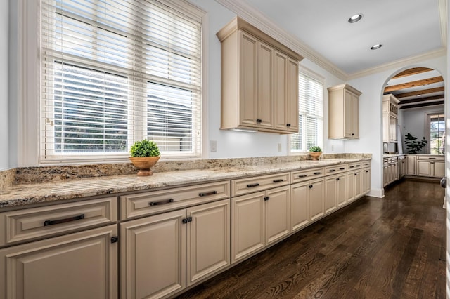 6054 Pelican Way, College Grove, TN 37046 - kitchen with dark wood-style floors, cream cabinetry, arched walkways, light stone countertops, and ornamental molding