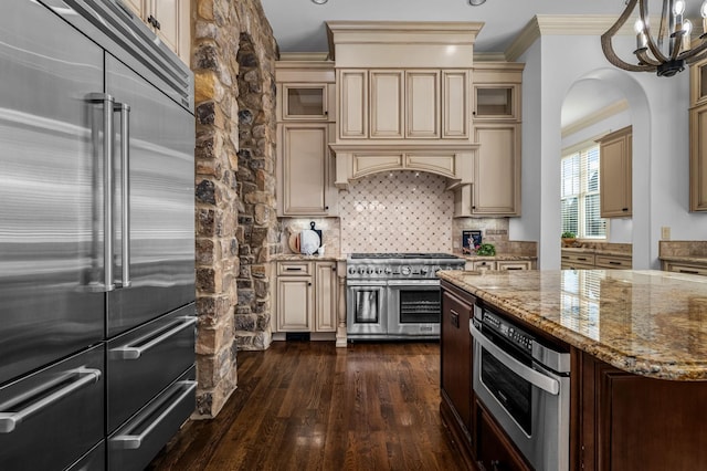 6054 Pelican Way, College Grove, TN 37046 - kitchen with high quality appliances, cream cabinetry, ornamental molding, dark wood finished floors, and light stone countertops