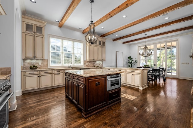 6054 Pelican Way, College Grove, TN 37046 - kitchen featuring cream cabinets, a chandelier, appliances with stainless steel finishes, beamed ceiling, and dark wood-style floors