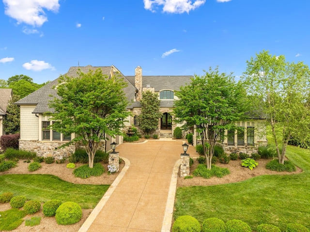 6054 Pelican Way, College Grove, TN 37046 - view of front facade with stone siding, a chimney, driveway, and a front lawn