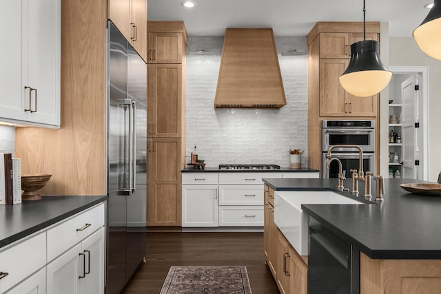 kitchen with stainless steel appliances, premium range hood, hanging light fixtures, and white cabinets