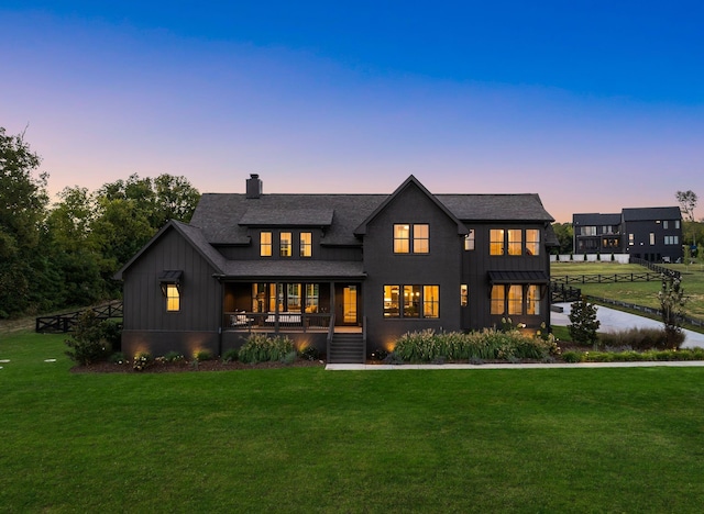 modern inspired farmhouse featuring board and batten siding, a lawn, and a chimney