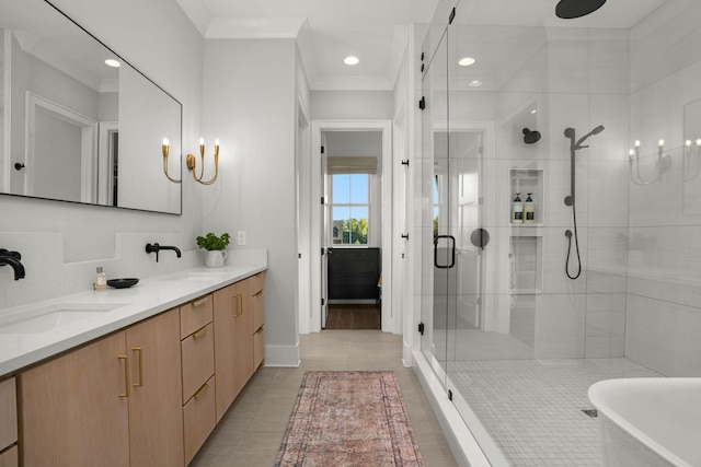 full bath with double vanity, a stall shower, tile patterned flooring, crown molding, and a sink