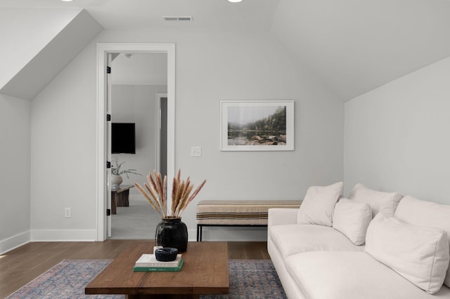 living area with dark wood-style flooring, visible vents, vaulted ceiling, and baseboards