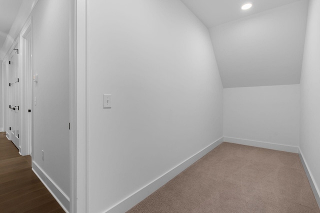 corridor featuring carpet, baseboards, vaulted ceiling, and recessed lighting