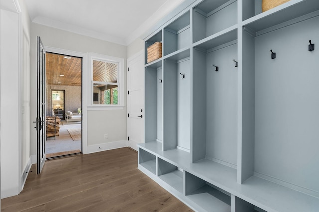 mudroom featuring crown molding, baseboards, and dark wood-type flooring